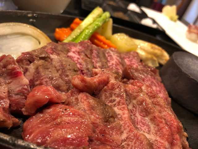 Photograph of a raw wagyu meat getting hot-stone-seared.